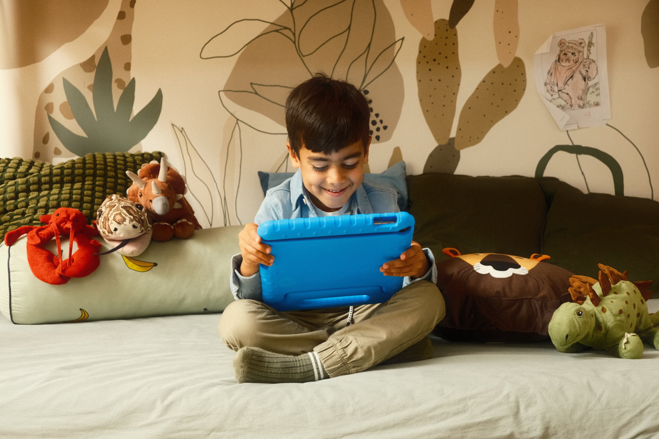 Jongetje speelt Squla op een tablet op bed.